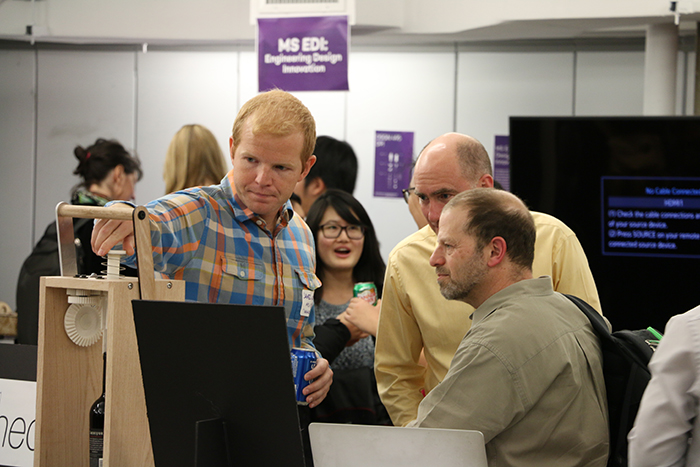 EDI student James Wilde presents his design to open wine bottles to Segal's Ed Colgate and Michael Peshkin.